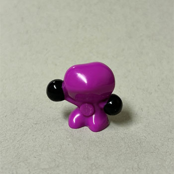 The black sphere hands contrast sharply with the bright magenta body, adding visual interest.