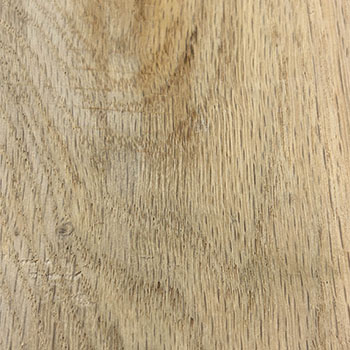 The surface of a wood plank is grainy and slightly uneven, with visible lines, knots, and natural imperfections that give it a tactile, organic feel.